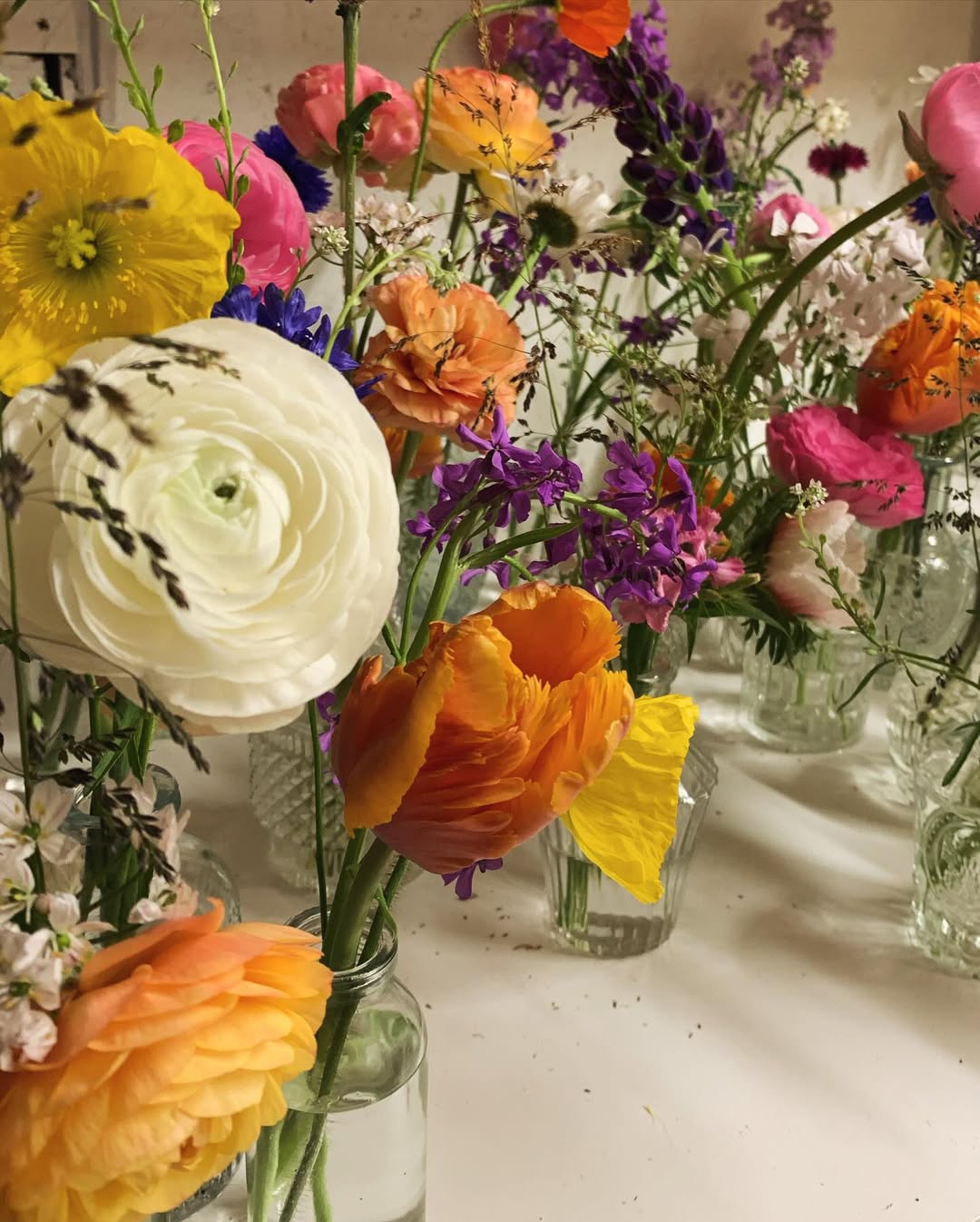 A row of colourful bud vases from a corporate workshop