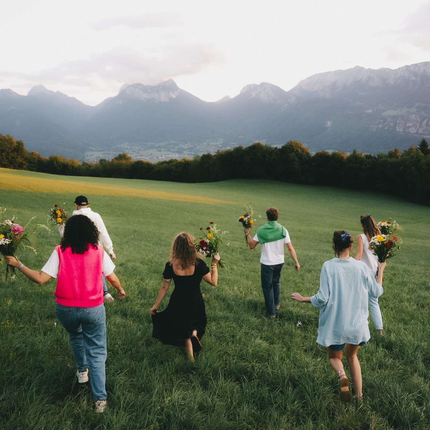 Friends walking through a meadow with the bouquets they made